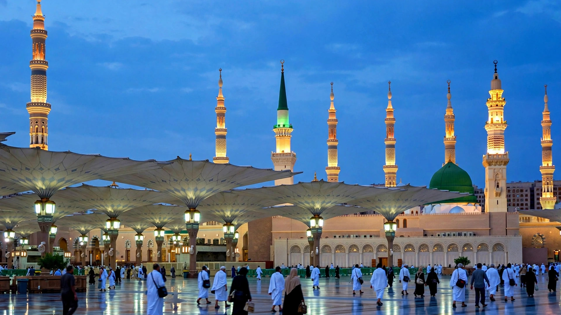 Prophet’s Mosque in Madinah at blue hour with pilgrims in the courtyard